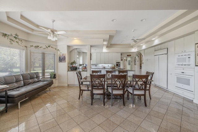 dining room featuring a ceiling fan, granite finish floor, a raised ceiling, baseboards, and recessed lighting