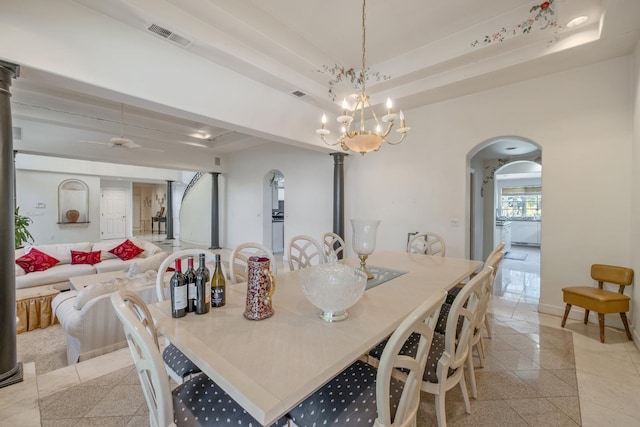 dining space with arched walkways, visible vents, granite finish floor, and ceiling fan with notable chandelier