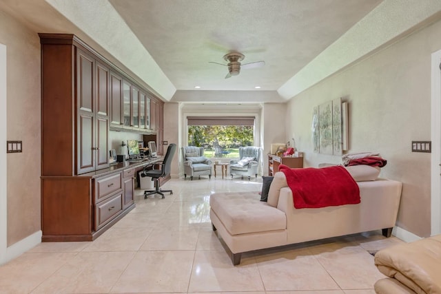 living room featuring baseboards, a ceiling fan, built in study area, and light tile patterned floors