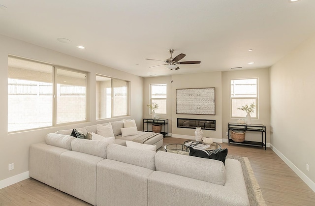 4338 Monarch Pl, Madera, CA 93636 - living area featuring a ceiling fan, light wood-style floors, baseboards, recessed lighting, and a glass covered fireplace