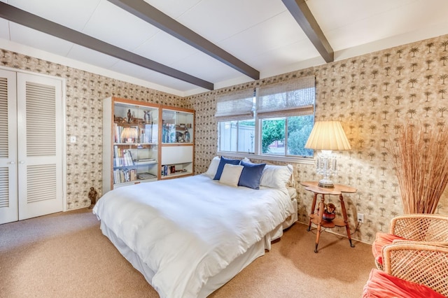 bedroom with beamed ceiling, wallpapered walls, and carpet