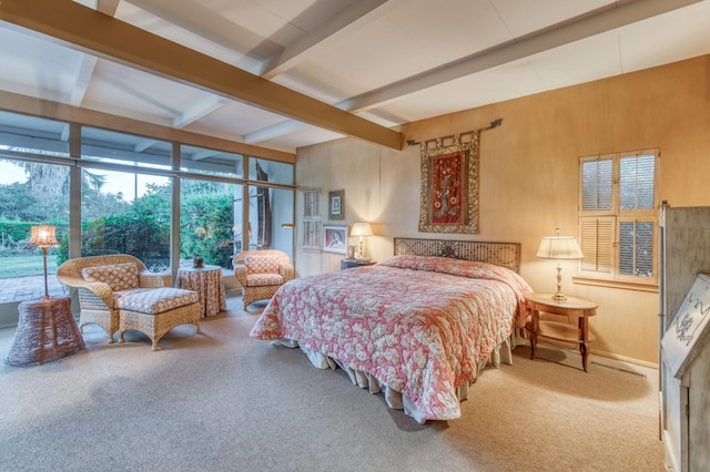 carpeted bedroom with beamed ceiling