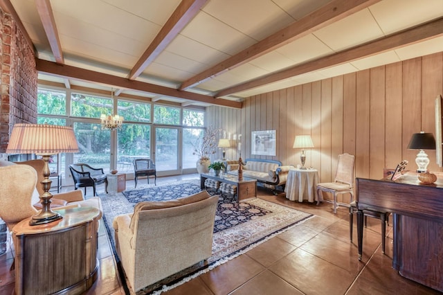 living room featuring an inviting chandelier, wood walls, tile patterned floors, and beamed ceiling