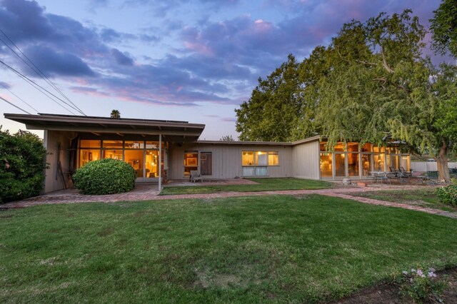 rear view of property featuring a yard and a patio