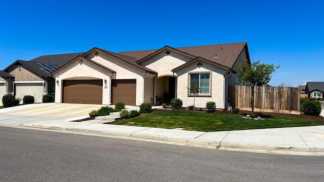 view of front of home featuring fence, concrete driveway, an attached garage, stucco siding, and a front yard