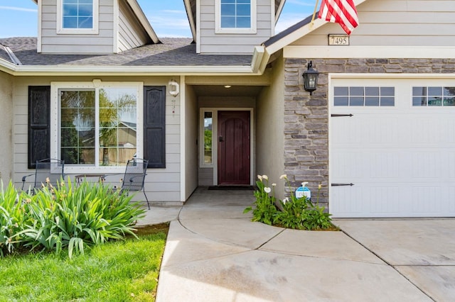doorway to property featuring stone siding, a shingled roof, and a garage