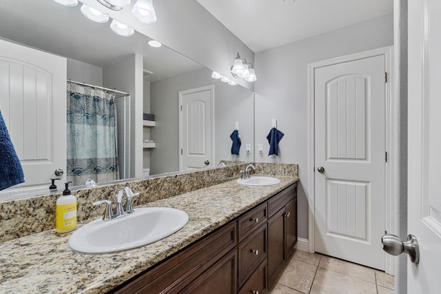 full bath with curtained shower, double vanity, tile patterned floors, and a sink