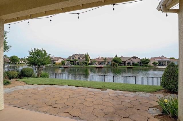 view of patio / terrace with a residential view, a water view, and a fenced backyard