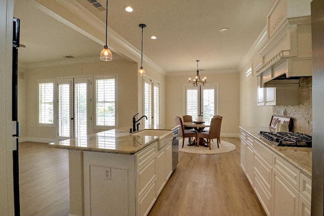 kitchen with a chandelier, dishwasher, light wood finished floors, gas stovetop, and crown molding