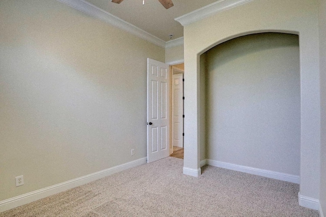 unfurnished bedroom featuring baseboards, ornamental molding, a ceiling fan, and carpet