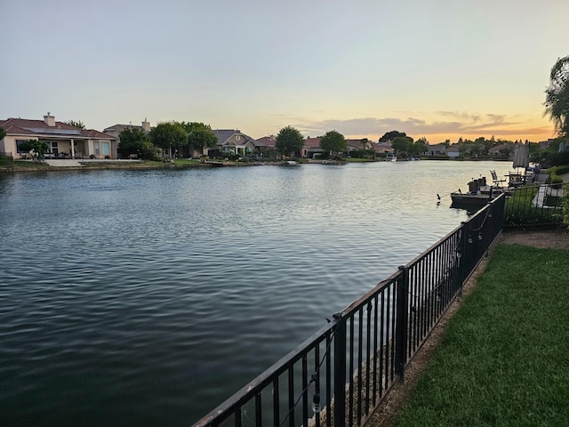 view of dock featuring fence and a water view