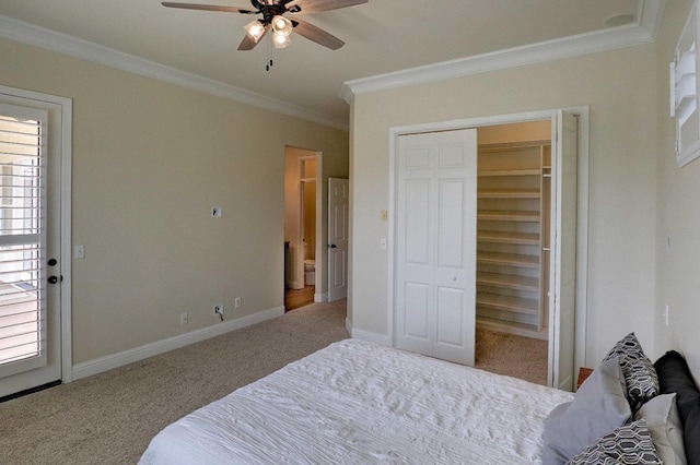 carpeted bedroom with baseboards, ornamental molding, a ceiling fan, and a closet