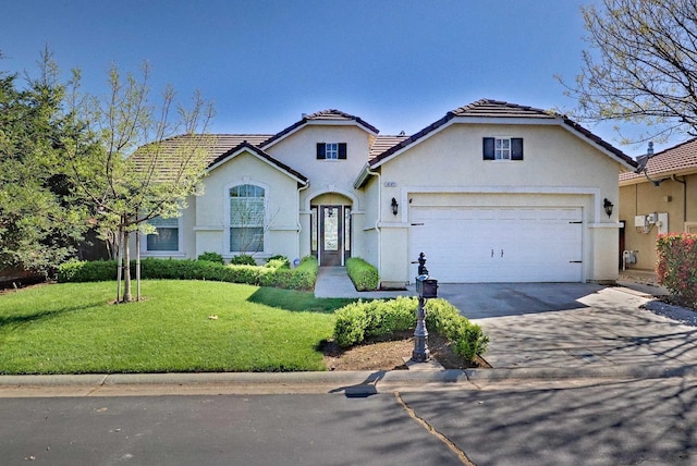 traditional home with driveway, a tiled roof, a front yard, an attached garage, and stucco siding