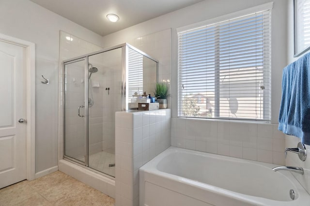full bathroom with a stall shower, a garden tub, and plenty of natural light