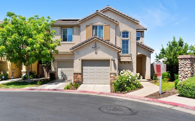 view of front of property with an attached garage, stucco siding, driveway, solar panels, and a tiled roof