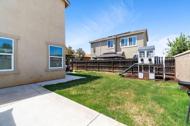 view of yard featuring a playground and a patio