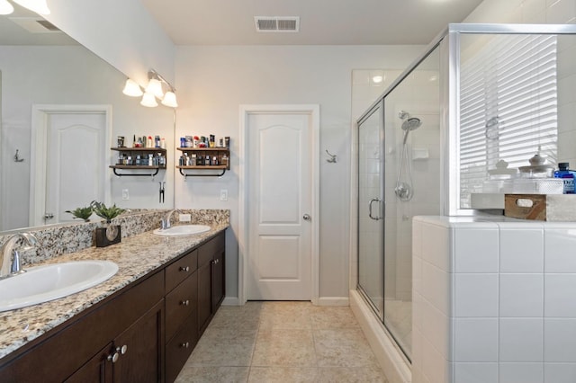 bathroom with a shower stall and double vanity