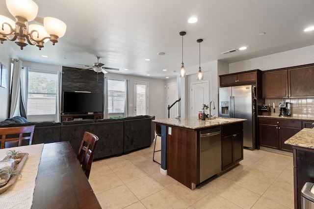 kitchen with stainless steel appliances, dark brown cabinets, light tile patterned floors, and recessed lighting