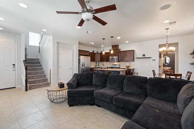 living room featuring light tile patterned floors, ceiling fan, stairway, recessed lighting, and a chandelier
