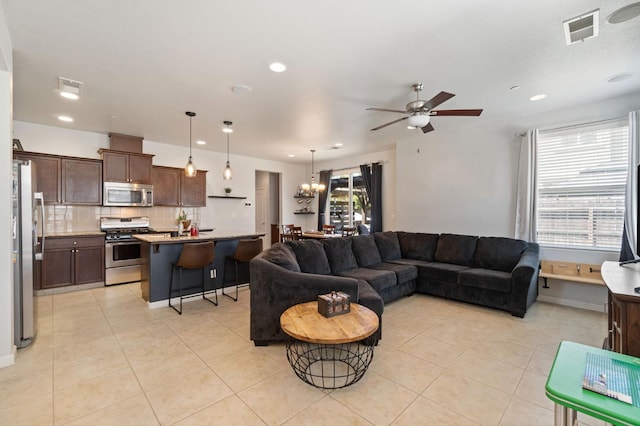 living room with a ceiling fan, light tile patterned floors, recessed lighting, and a chandelier