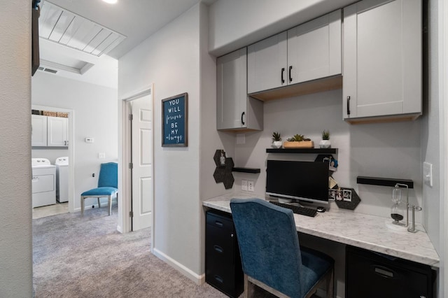 home office with built in desk, washing machine and clothes dryer, light carpet, and baseboards