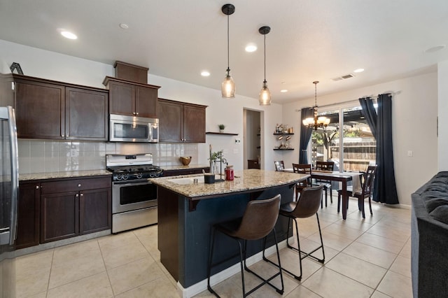 kitchen with stainless steel appliances, light tile patterned flooring, a chandelier, dark brown cabinetry, and recessed lighting