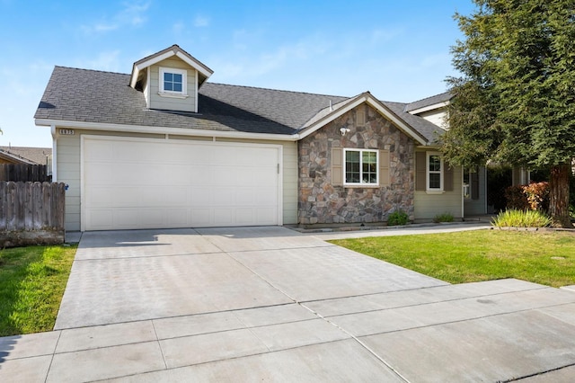 6675 E Montecito Ave, Fresno, CA 93727 - ranch-style house with concrete driveway, stone siding, an attached garage, fence, and a front yard