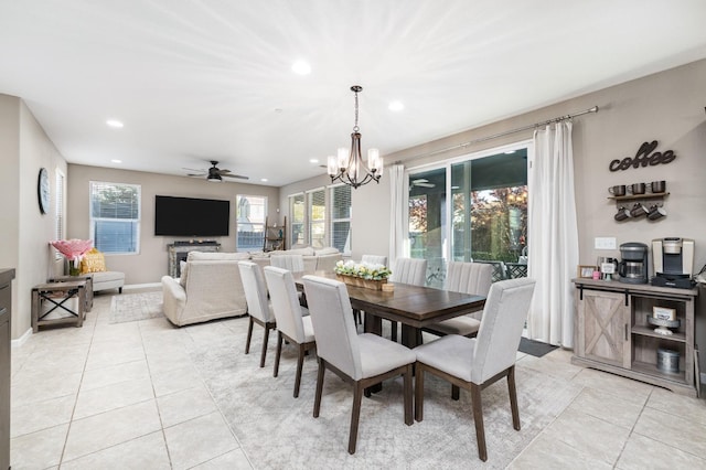 dining space featuring light tile patterned flooring, baseboards, recessed lighting, and ceiling fan with notable chandelier