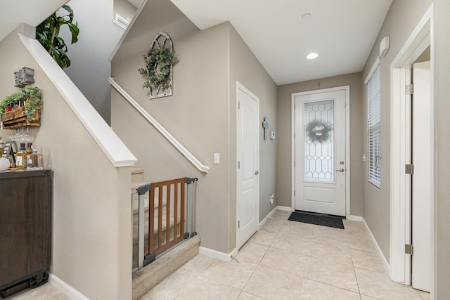 foyer entrance featuring baseboards, recessed lighting, stairs, and light tile patterned flooring