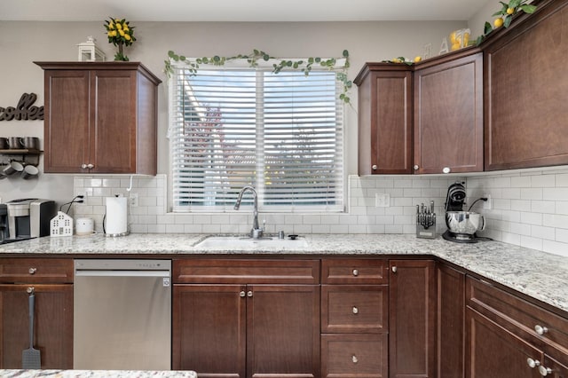kitchen featuring light stone countertops, decorative backsplash, a sink, and dishwasher