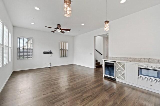 2067 E Axelson Dr, Fresno, CA 93730 - unfurnished living room with wine cooler, recessed lighting, stairway, and dark wood finished floors