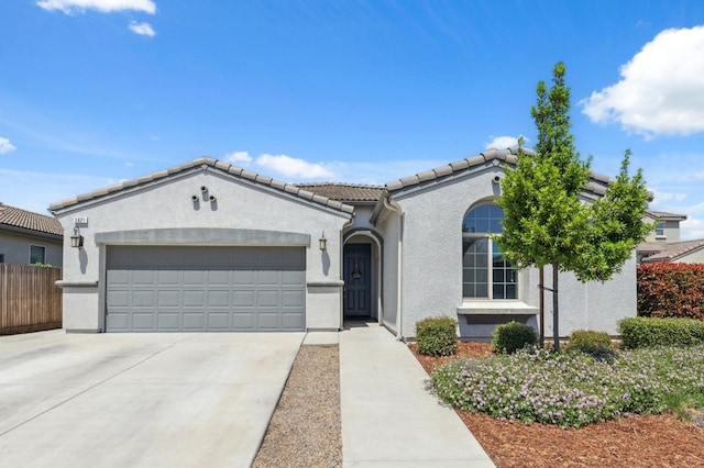 3821 Leigh Ln, Clovis, CA 93619 - view of front of house with a tiled roof, driveway, fence, an attached garage, and stucco siding