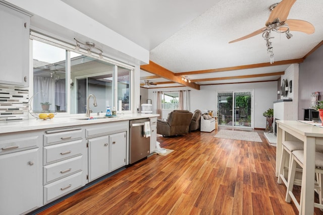 kitchen featuring wood finished floors, a sink, open floor plan, dishwasher, and light countertops