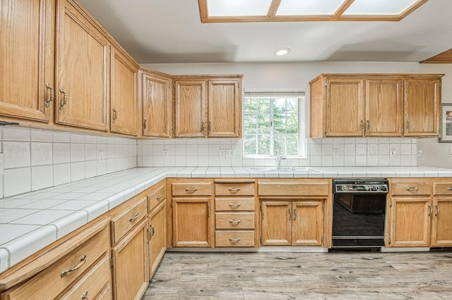 42153 Hemlock Ln, Shaver Lake, CA 93664 - kitchen with black dishwasher, recessed lighting, backsplash, light wood-type flooring, and a sink