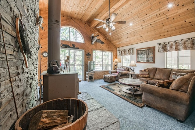42153 Hemlock Ln, Shaver Lake, CA 93664 - carpeted living room with high vaulted ceiling, a ceiling fan, wooden ceiling with exposed beams, and wooden walls