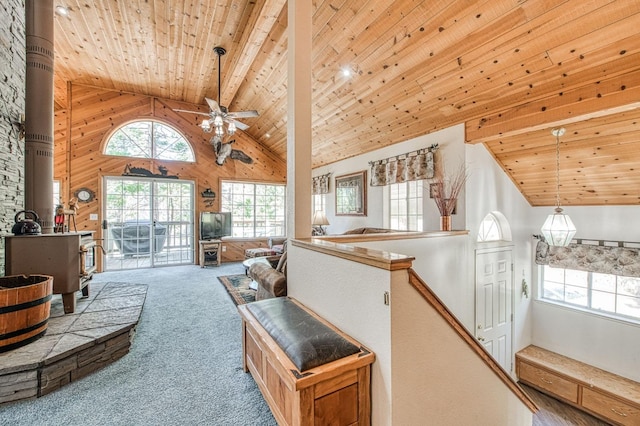 42153 Hemlock Ln, Shaver Lake, CA 93664 - living area with high vaulted ceiling, a wood stove, wood ceiling, carpet flooring, and a ceiling fan