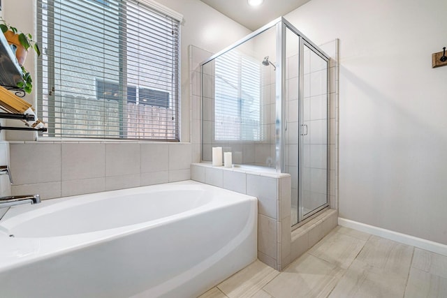 full bathroom featuring a shower stall, baseboards, a bath, and tile patterned floors