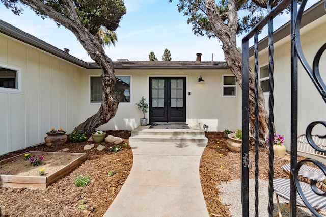 entrance to property featuring french doors and stucco siding