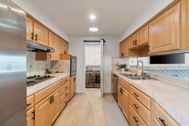 340 W Escalon Ave, Fresno, CA 93704 - kitchen featuring appliances with stainless steel finishes, tile countertops, independent washer and dryer, under cabinet range hood, and decorative backsplash