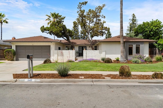 single story home featuring an attached garage, fence, driveway, and a front yard