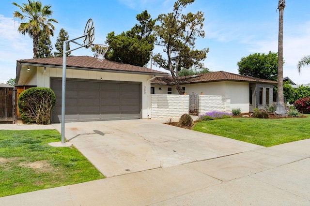 ranch-style home with a gate, fence, a front lawn, concrete driveway, and an attached garage