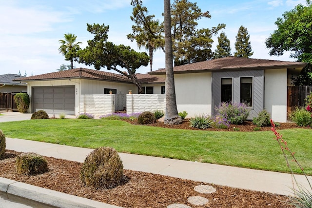 ranch-style house featuring a garage, driveway, a front lawn, and fence