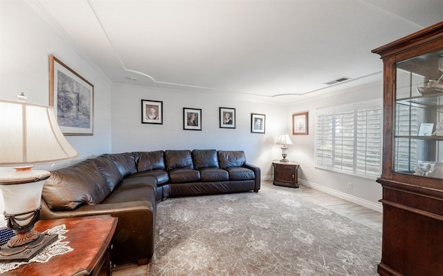 living area with visible vents, baseboards, and ornamental molding