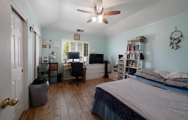 bedroom with ceiling fan, vaulted ceiling, hardwood / wood-style floors, and visible vents