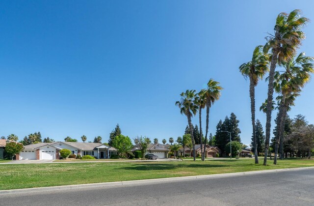 view of front facade with a front lawn, driveway, a residential view, and an attached garage