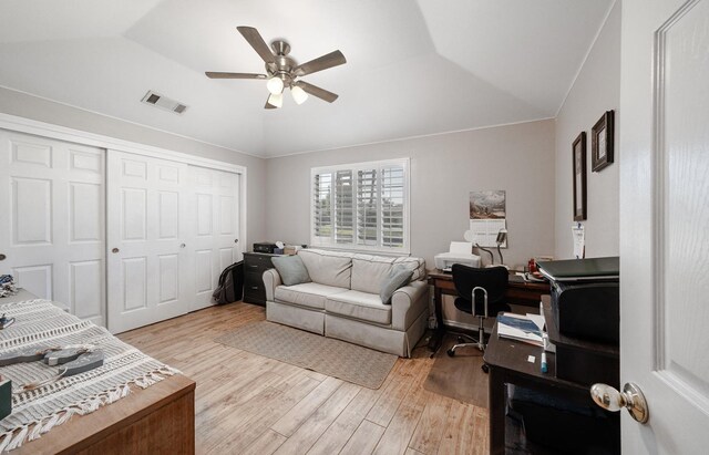 bedroom featuring a closet, ceiling fan, light wood finished floors, lofted ceiling, and visible vents