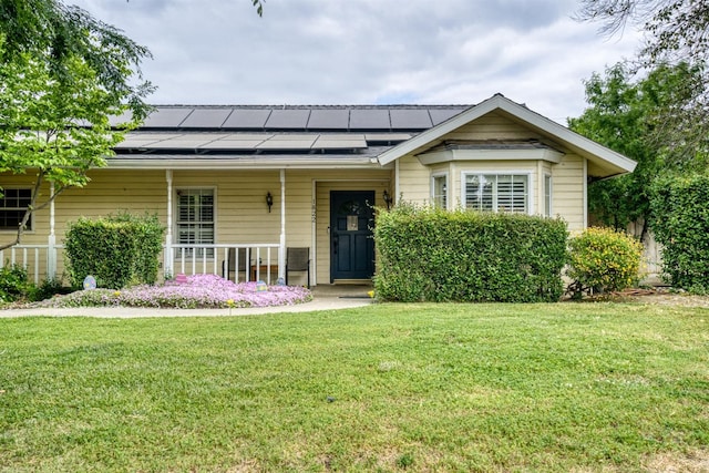 view of front of home with solar panels, a front lawn, and covered porch
