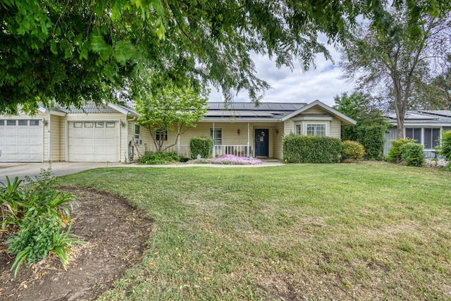 single story home featuring a front lawn, solar panels, concrete driveway, covered porch, and an attached garage