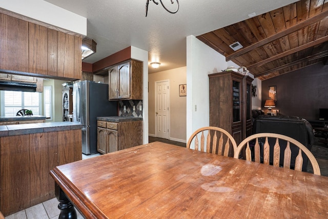 dining room featuring visible vents, baseboards, and wooden ceiling