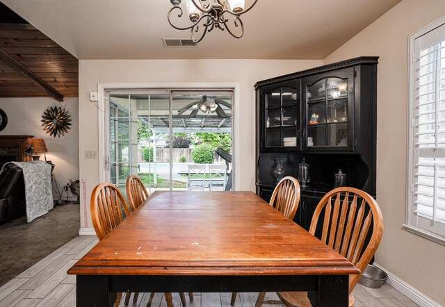 dining area with light wood-type flooring, visible vents, and a healthy amount of sunlight